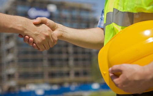Architects shaking hand at construction site